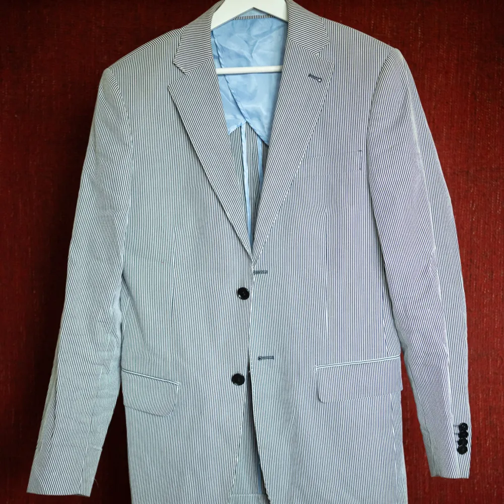 En fin, knappt använd blå-vitrandig kavaj i stl 46 från Easy Wear. Snygg och perfekt sommarkavaj!  Material: 100 % bomull Foder: 50 % viskos, 50 % polyester. Kostymer.