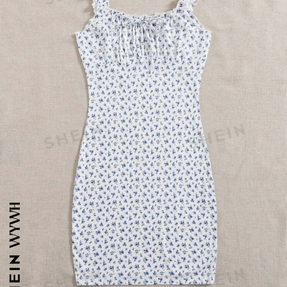 En kort vit klänning med blåa blommor på. Denna har aldrig kommit till användning så den är precis som ny😍😍😍. Klänningar.