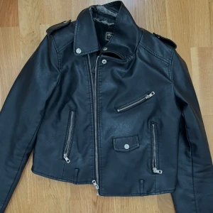 Svart skinnjacka  - Den är en jättebra skinnjacka speciellt för våren men den är lite sliten 