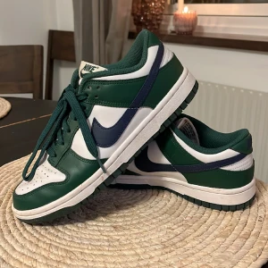 NIKE low dunk woman ”gorge green” str38.5  - Säljer mina low dunks från Nike, använd ett fåtal gånger, men kommer inte till användning då jag har många andra, finns inte tydliga tecken på användning, storlek 38,5, passar till både 38 och 39. Nypris ca 1.500