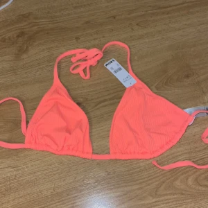 Orange ribbad bikiniöverdel - Orange ribbad bikiniöverdel från Cubus! Lappar kvar, storlek M