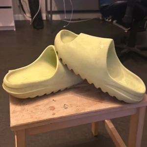 Yeezy slides glow green  - Jag vill sälja mina yeezy slides glow green för de kommer aldrig till användning som ni ser så är de  lite smutsig innuti så de är använda tror det är riktiga min pappa köpte de till mig så vet ej orginal box kommer inte med pris kan diskuteras 