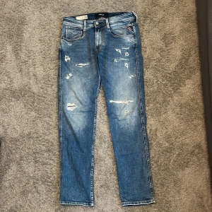Replay Jeans - Säljer nu mina ljus blåa jeans från Replay med feta slitningar. Sparsamt använd och inga synliga skador!