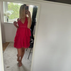 Klänning  - Säljer min snygga rosa klänning med volanger! Sjukt snygg, köpte den utomlands så jag har inte sätt någon ha likande. Jätte fin färg till sommaren! Osäker på vad det är för storlek men kan tänka mig S/ M då man kan sjölv kan spänna den 