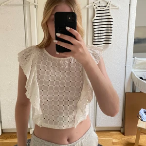 Volangtopp från Zara - Oanvänd broderad volangtopp från Zara med prislappen kvar. Hålbroderad med volanger på armarna.