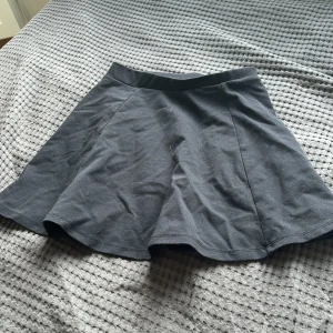 Svart minikjol - Svart minikjol som är tajt i midjan och sedan pösig