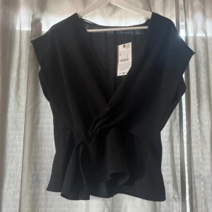 Populär Zara Blus med knytning  - Populär Zara blus med knytning. Aldrig använd då den är för stor för mig. Storlek XL men skulle säga passar även L. Har dragkedja vid sidan. Bra skick och aldrig använd. Orginal pris 329kr