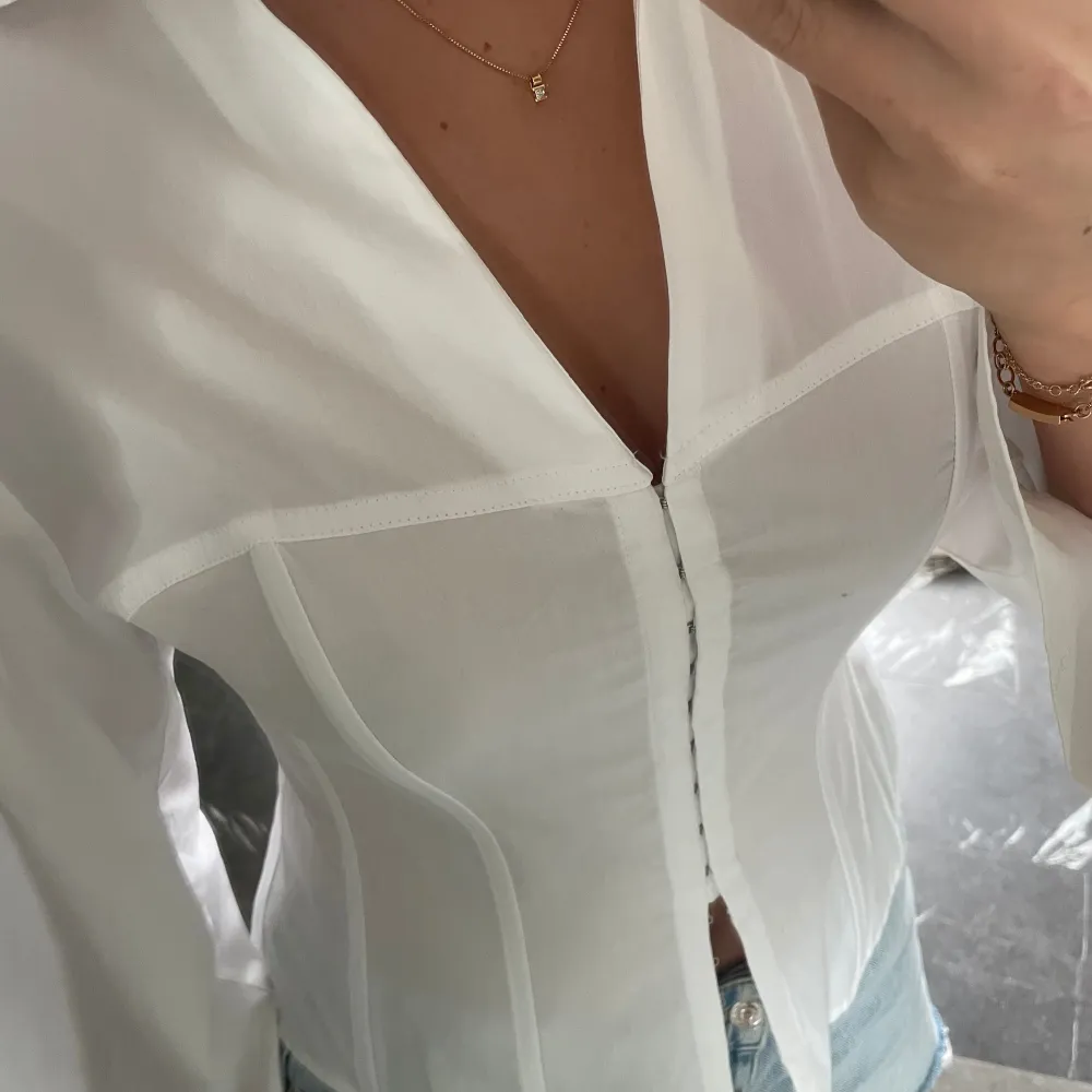 Jättesnygg vit korsettskjorta från Zara, helt ny i storleken L men motsvarar mer en M. Skjortor.