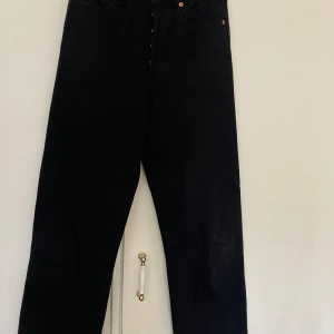 Levis svarta jeans, storlek 26 - Snygga svarta jeans från Levi's med hög midja och rak ben.  Modell Ribcage straight.   Storlek: W 26, L 27.  97% bomull, 2% polyester, 1% elastane.   Mjuka och sköna ha på sig.   Nästan oanvända så precis som nya.  Nypris: 1300kr