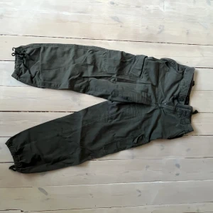 Cargobyxor  - Kargobyxor i grov bomull. Militärgröna. Asos design. Stl 36. Bra skick. 
