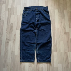 Carhartt Og Single Knee Pant - 699kr - Carhartt Og Single Knee Pant i blue(one wash), storlek Large. 100% bomull, carpenter fickor på båda sidorna och lite slitage längst med benämningen och ca 10cm ovanför. För mått/fler bilder skriv privat.