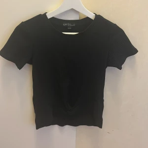 En svart kortärmad tröja men en Knut  - Tröjan har en Knut längst ner, Den är använd, från Ullared