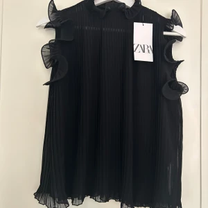 Topp - Supersnygg volangtopp från zara!💘Den är ganska genomskinlig. Aldrig använd eftersom att det var fel storlek. Nypris 329 kr men jag säljer för 200 kr!