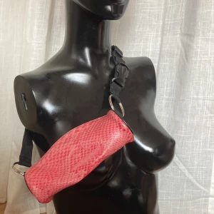 Rosa fannypack - Liten väska med justerbart band i fake ormskinn. 