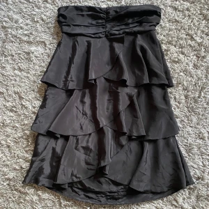 Volangklänning  - Säljer denna superfina klänningen då den är lite för lång för mig som är 155cm. Klänningen är i ett lite glansigare material och har inga band. Längst upp sitter det typ gummi som gör att den inte åker ner så lätt. Är i storlek 38/M💕