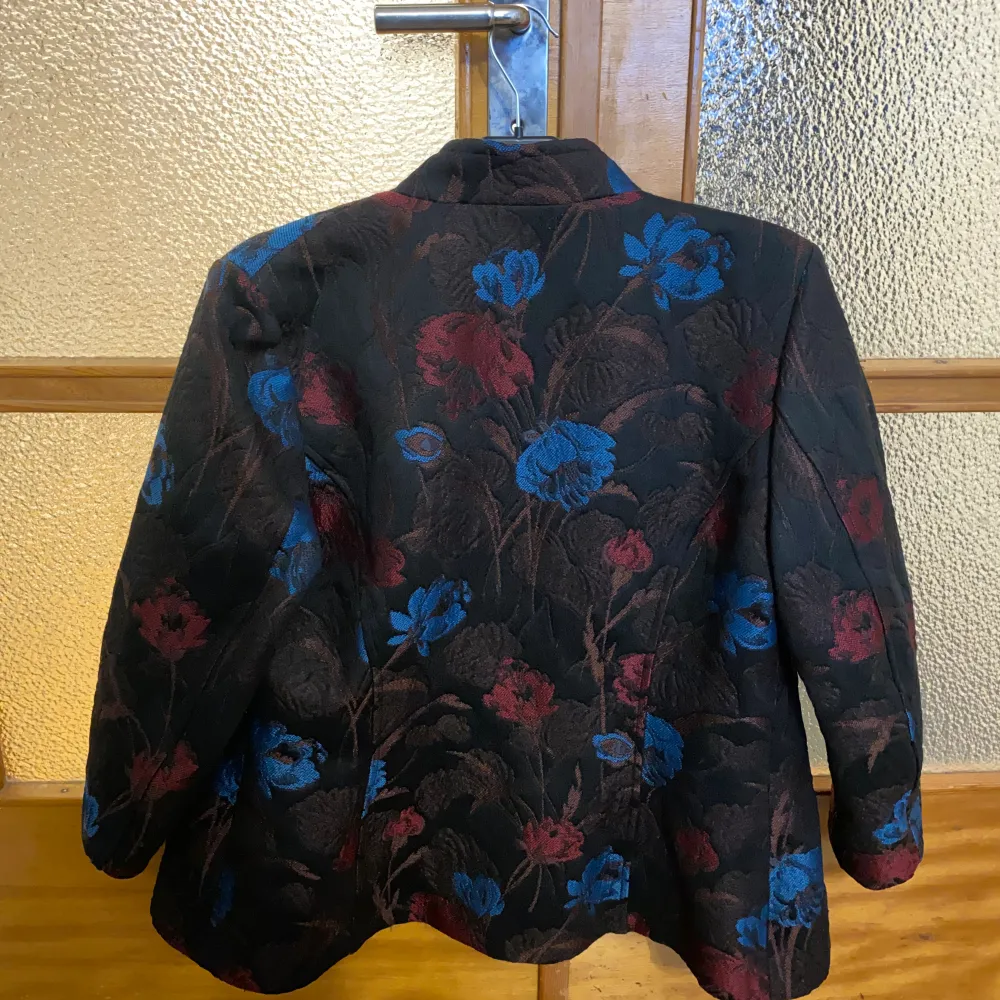 A pre owned blazer in size 42 It has flowers embroided and has like a tapestry kind of fabric!  Measurements laying flat:  Pit to pit 53cm  Length 70cm . Kostymer.