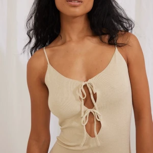 Lång stickad klänning med knytdetaljer - ”Benen Hostalet x NA-KD oanvänd långklänning, med knytdetaljer vid bysten och smala axelband 🤍 prislapp kvar  