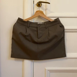 Brun lågmidjad kjol - Säljer denna helt oanvända kjolen från NAKD! Superfin nu i vår och sommar🥹