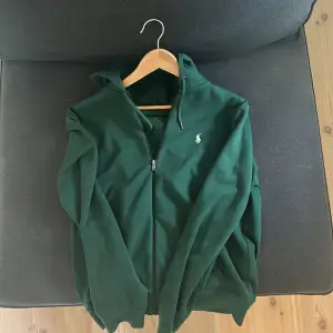 Knappt använd grön Ralph lauren hoodie, den är i väldigt bra skick och passar i storlek M. Nypris på den är runt 2000kr