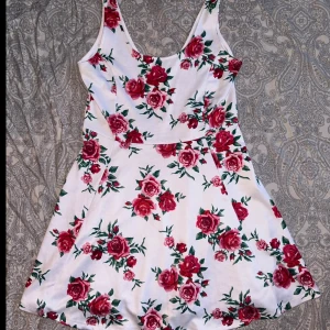 Kort klänning, vit/röd blommor - Kort vit klänning med röda blommor.