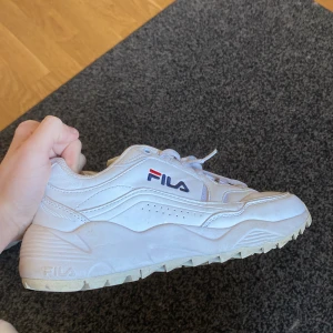FILA skor - Hej jag säljer mina gamla Fila skor, jag använde dem lite i 6an och spelade fotboll med dem så vänster skon är lite smutsig men de går och tvätta bort, sköna o nice nu till våren/sommaren. Har tyvär även ingen box kvar 