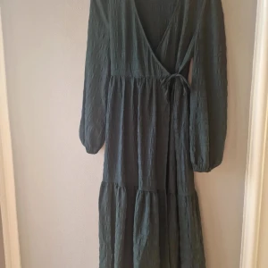 Bäckebölja omlottklänning  - Mörkgrön/mossgrön omlottklänning bäckebölja- Monki 💚  Storlek 36/S, reglerbar midja så passar även större! Nyskick utan anmärkningar!