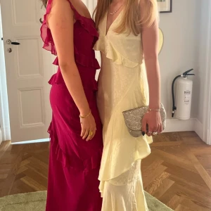 Balklänning  - Säljer min så så fina balklänning med volanger och en arm, det funkar även att ha klänningen som en bandue och vika ner axelbandet. Använd en gång. Storlek xs men passar s. Jag är 167cm och hade 8cm klackar och klänning nuddade fortfarande marken💗