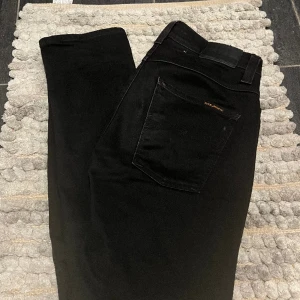 Nudie Jeans Svarta Grim Tim - Snygga svarta jeans från Nudie i modellen Grim Tim, fint skick, storlek W32 L32