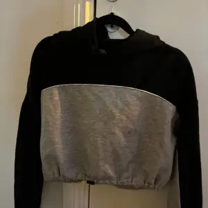 En svart grå hoodie  Ganska kort  Super fin 