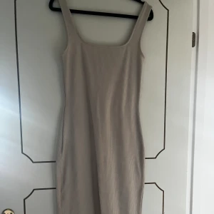 Ribbad tight klänning - Säljer nu denna superfina taighta ribbade klänningen! Den går lite under knät och är i en beige färg. Skriv vid fler bilder eller intresse!💛
