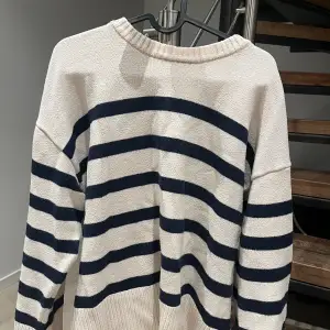 Säljer denna randiga stickade tröjan från Zara i strl L. Den är vit med mörkblå ränder och har en kort slits på sidorna.   Pris kan diskuteras