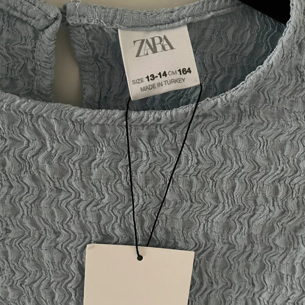 Ljusblå t-shirt med spets från Zaras barnavdelning. Aldrig använd och lappen är kvar. Storlek 164 men är som S. T-shirts.