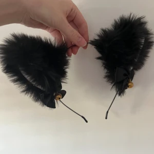 Svarta kattögon / cat ears  - Bra skick, knappt använda och är mjuka. Bjällrorna hörs när man rör huvudet. Vit inuti öronen. Går att pruta