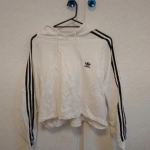 Adidas hoodie - Säljer en Adidas hoodie i strl M, den är magkort. Den är endast använd en gång, den är som helt ny. Den köptes dyrt! Jag säljer den för 100kr! Priset kan diskuteras vid snabb affär!