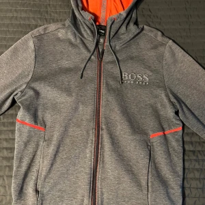 Hugo boss hoodie med Dragkedja - Har använd den för 1 årsen och sen så har den bara hänt i skåpet men den passar inte mej nu så därför säljare jag den och är i bra sikt om du är intresserad hör av till mig jätte jännna eller om du har frågor.