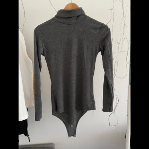 Grå body med polokrage - Mjukt stretchigt tyg! Uppskattar storleken till S.