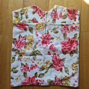 Blommig spetstopp med dragkedja - Passar mindre byst jättefint material som är stretchigt Har en till i annat mönster