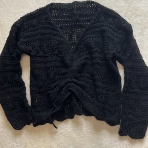 Stickad tröja med snörning  - Snygg stickad tröja att ha nu till sommaren. Snörning fram som kan justeras beroende på hur mycket man vill visa magen.   Storlek XS-S