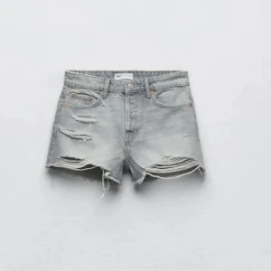 Grå jeansshorts med slitningar - Säljer dessa populära och slutsålda gråa lowwaist shorts från Zara! Kommer ej till användning och darför säljer jag dom. De är ganska små i storleken, 38 passar mig som ofta har xs-s