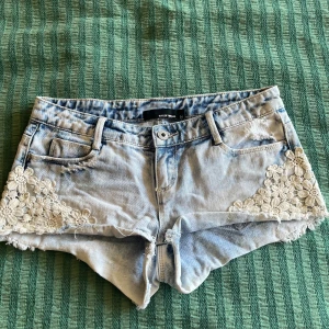 Lågmidjade shorts  - Jättefina lågmidjade shorts med spetsdetaljer på sidorna. Måttet 37 rakt över i midjan
