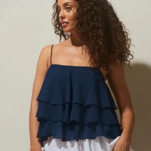 Volangtopp GinaTricot - Superfin mörkblå volangtopp från ginatricot i storlek 34. Passar mig som brukar ha xs/s. Lappar kvar, helt oanvänd. Nypris 299 kr. 