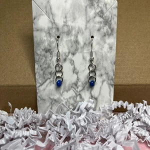 Mörkblåa örhängen - Örhängen med mörkblåa pärlor, ska vara i rostfritt stål.