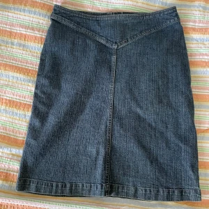 Jeanskjol från HENNE - En klassisk jeanskjol vintage hm i storlek 40. Kjolen har en rak passform och är knälång. Den är tillverkad av denim och har en dragkedja baktill.