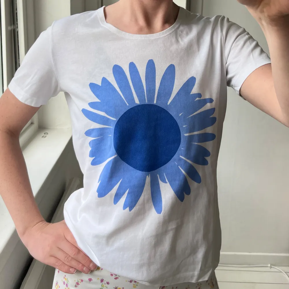 Söt Marimekko t-shirt med stor blå blomma, och en likadan mindre högst upp i bak på ryggen. I fint vintage skick.. T-shirts.