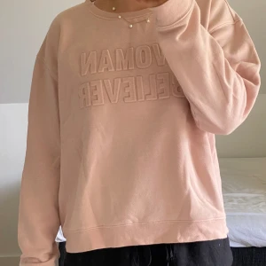 Ljusrosa/lite aprikosfärgad sweatshirt  - Ljusrosa/lite aprikosfärgad sweatshirt från Monki 🩷 tryck med ”Wiman Believer” på. Sparsamt använd och fortfarande mycket fint skick! Passar någon i storlek M eller någon i S/XS om man vill ha den mer oversize.