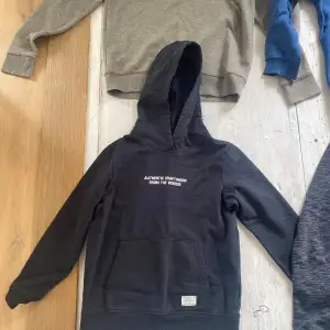 En svart hoodie med texten 'AUTHENTIC CRAFT WORK FROM THE WOODS' på bröstet. Tröjan har en ficka framtill och en huva. ett riktigt fint pris, 40kr! Ett riktigt bra skicka är tröjan i. hör av er vid frågor och liknande☺️