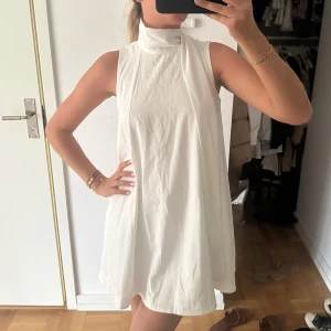 Klänning - Klänning med ett band som man kan ha lite hur man vill, knyta som rosett eller ha som på bilden. 