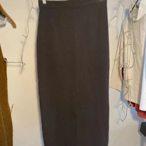 Lång kjol - Lång kjol i filtaktigt material med slits bak. Fint skick!