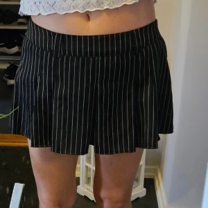 Svart/vit minikjol - Oanväd Snygg svartvit randig kjol med veck. Kjolen har en rak passform och en något kortare längd. Dragkedja I sidan, inbyggda shorts. Hällor för att kunna ha skärp i. Tyvärr är lappen borttagen men det är strl S/M. Katt finns I hemmet
