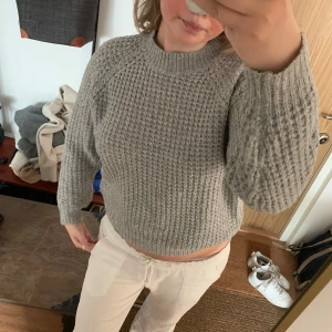 Super fin stickad tröja - Säljer denna gråa stickade tröja från lager 157. tröjan är i bra skick förutom att den har lite hål på ena övre under armen (se på bild två)